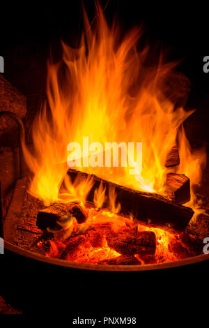 Campfire - Vertical - Close up view of blazing wood fire in a camp fire pit. Stock Photo