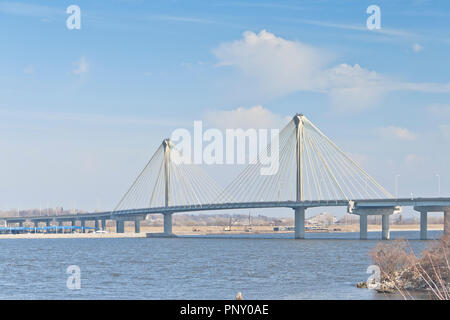 The Clark Bridge under droopy clouds and a pale blue sky seen from the Lincoln-Shields Recreation Area on the Missouri side of the Mississippi River. Stock Photo