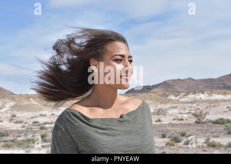 mixed race young girl in the desert with hair blowing in the wind Stock Photo