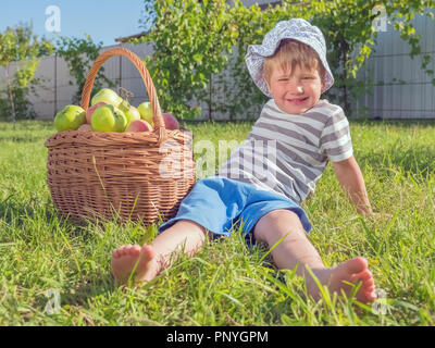 He healthy food concept. Cute boy sitting near apples. Taking a rest after hard work. Stock Photo