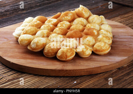 Hong Kong style egg waffle on wooden board. bubble waffle. street food waffles Stock Photo