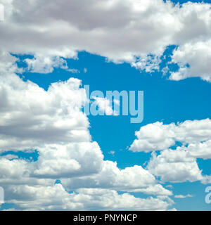 Puffy cumulus clouds on dazzling blue sky Stock Photo