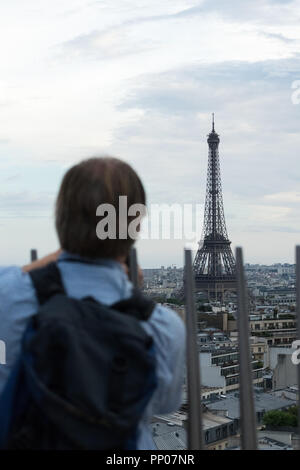 Man enjoying the view of the Eiffel Tower from Arc de Triomphe rooftop