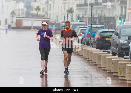 Hastings, East Sussex, UK. 23rd Sep, 2018. UK Weather: Heavy rain and driving wind in the seaside town of Hastings this morning, temperatures have dropped below 13°C. These joggers brave the wet and windy conditions running along the promenade. © Paul Lawrenson 2018, Photo Credit: Paul Lawrenson / Alamy Live News Stock Photo