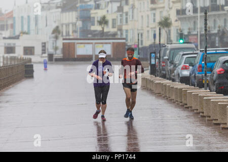 Hastings, East Sussex, UK. 23rd Sep, 2018. UK Weather: Heavy rain and driving wind in the seaside town of Hastings this morning, temperatures have dropped below 13°C. These joggers brave the wet and windy conditions running along the promenade. © Paul Lawrenson 2018, Photo Credit: Paul Lawrenson / Alamy Live News Stock Photo