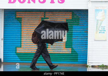 Hastings, East Sussex, UK. 23rd Sep, 2018. UK Weather: Heavy rain and driving wind in the seaside town of Hastings this morning, temperatures have dropped below 13°C. This man nearly loses his umbrella as a gust of wind turns it inside out. Photo Credit: Paul Lawrenson / Alamy Live News Stock Photo