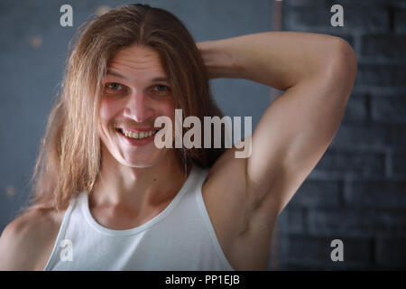 A young man with long hair cut a lock Stock Photo