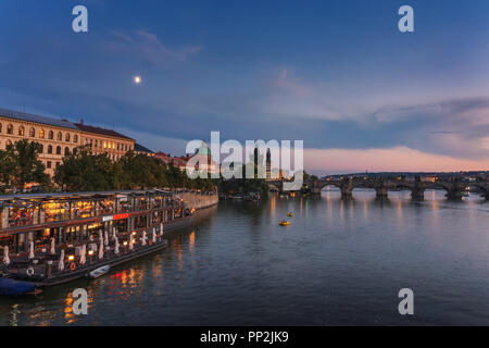 Prague, Czechia - September 19, 2018 : People eat at the famous Marina restaurant along the Vltava river with Charles bridge in the background at suns Stock Photo