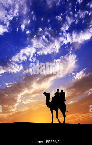 Walking with camel through Thar Desert in India, Show silhouette and dramatic sky Stock Photo