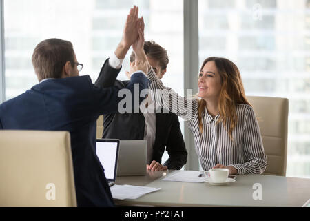 Workers giving high five motivating for success Stock Photo