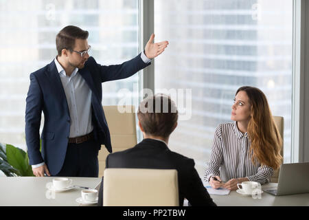 Mad male worker asking female partner leave meeting Stock Photo