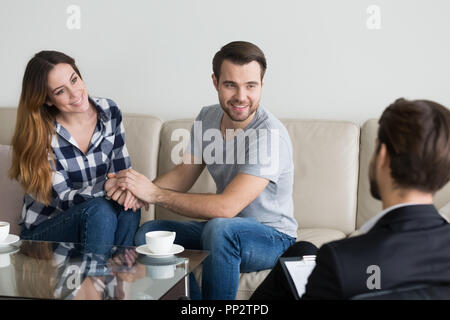 Happy couple holding hands reconciled after psychologist therapy Stock Photo