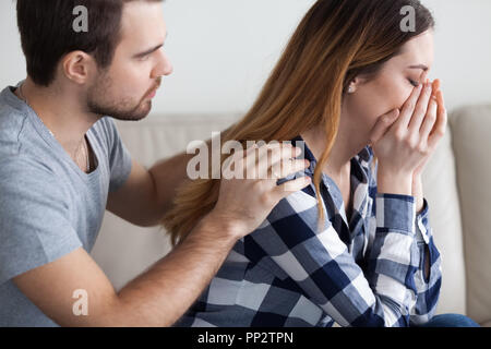 Caring man comfort crying wife making peace after fight