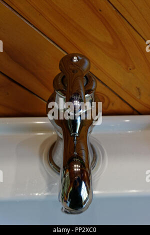 A stainless mixer tap with H and C marked on it for hot or cold Stock Photo