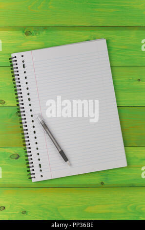 Notepad and pen on a green wooden table Stock Photo