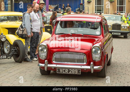 Watching the parade at a classic car show in town. Stock Photo