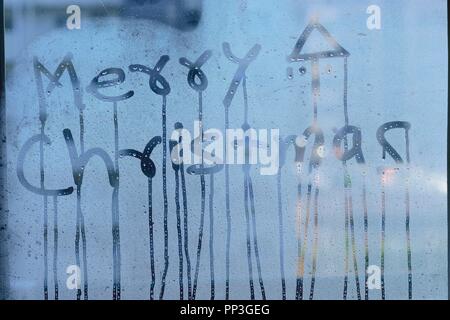 Texture of water droplets on clear window glass with Merry Christmas text Stock Photo