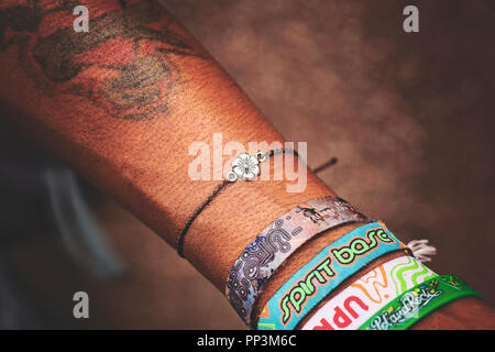 Prague, Czech republic, August 30, 2018: Male wrist with tiny jewelry and local festival bracelets Stock Photo