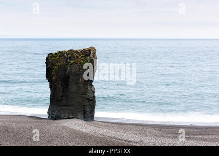 Alone basalt rock on Iceland coastline. Landscape photography Stock Photo