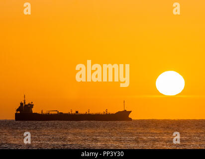 Crosshaven, Cork, Ireland. 25th September, 2017. Oil tanker Thun Galaxy silhouetted by the rising Sun while at anchor outside Cork Harbour, Ireland.- Stock Photo