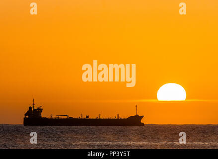 Crosshaven, Cork, Ireland. 25th September, 2017. Oil tanker Thun Galaxy silhouetted by the rising Sun while at anchor outside Cork Harbour, Ireland.- Stock Photo