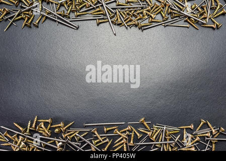 Screws and nails for wood, lying on a black background. Stock Photo