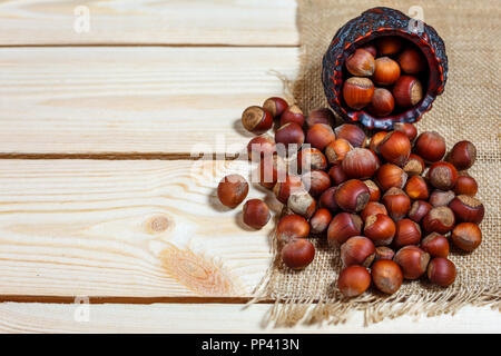 hazelnut lies on a wooden background of large nuts. Stock Photo