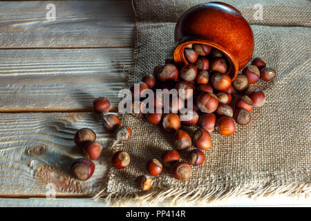 hazelnut lies on a wooden background of large nuts. Stock Photo