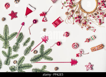 Christmas decorations flat lay on white background, top view. Various Christmas objects: wreath, tree, fir branches, red stars, balls,cones, sled for  Stock Photo