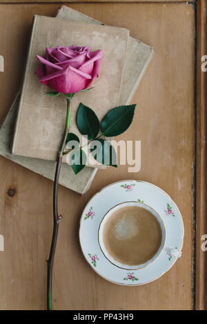 Coffee in a vintage teacup with a faded pink rose Stock Photo