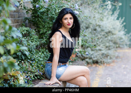 Beautiful Indian woman sitting on a wall
