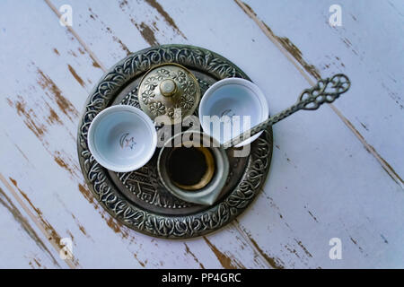 A tray with two traditional empty coffee cups, Turkish coffee kettle and Turkish delight cup together. Stock Photo