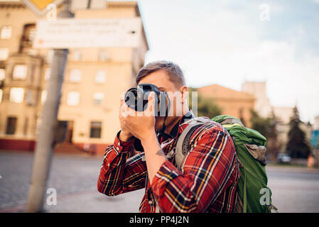Man takes pictures of tourist attractions of the city on the camera. Summer travelling, hike adventure over sightseeing Stock Photo
