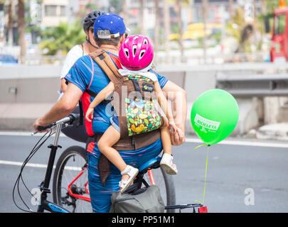 Cyclist carrying child on back. Stock Photo