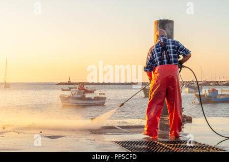 Man water jetting pier at dawn Stock Photo