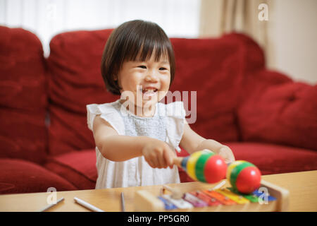 baby girl play maracas at home Stock Photo