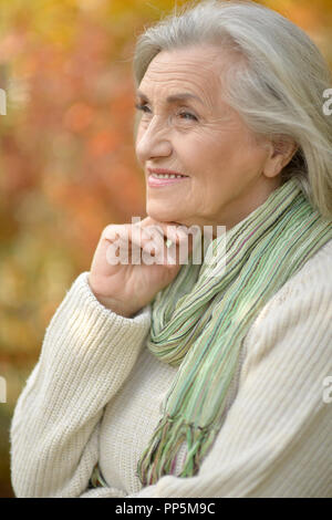 Portrait of senior woman in autumn park Stock Photo