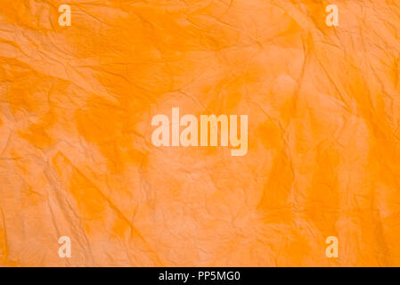 orange creased colored tissue paper background texture macro Stock Photo