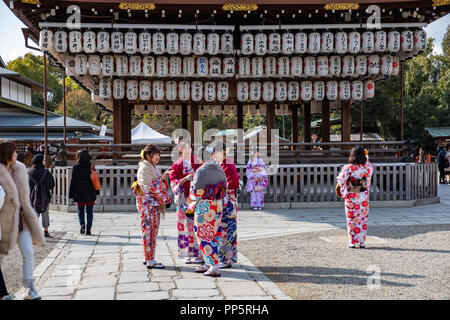 KYOTO, JAPAN - 08 FEB 2018: Colorful young japanese girls dressed in traditional kimonos chatting in temple Stock Photo