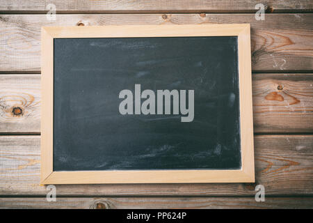 Back to school. Blank blackboard with frame on wooden wall background, copy space Stock Photo