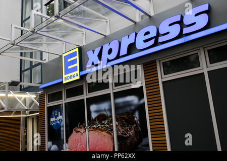 A logo sign outside of an Edeka Express retail grocery store in Munich, Germany, on September 2, 2018. Stock Photo