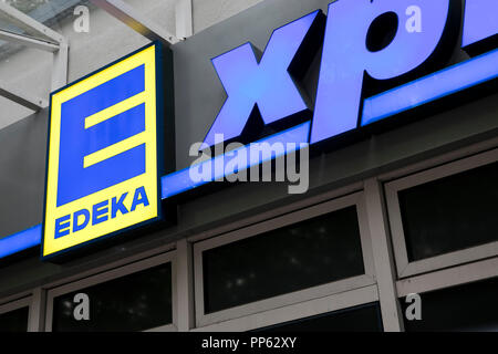 A logo sign outside of an Edeka Express retail grocery store in Munich, Germany, on September 2, 2018. Stock Photo