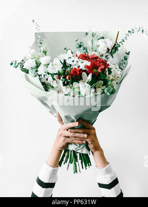 https://l450v.alamy.com/450v/pp631w/flower-arrangement-against-white-background-close-up-photo-woman-is-holding-a-large-bouquet-of-flowers-in-a-paper-package-in-her-hands-pp631w.jpg