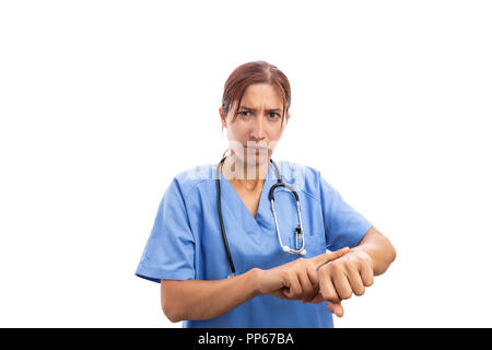 Angry bossy woman nurse or doctor making late time gesture by pointing on wrist as medical profession stress duty concept isolated on white background Stock Photo