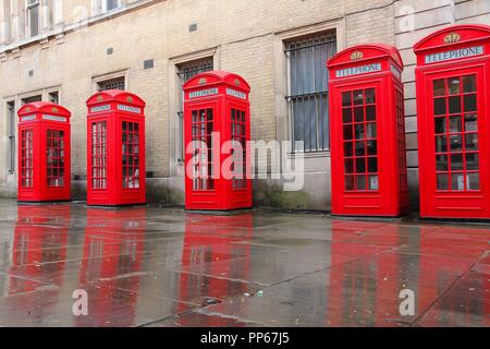 London, United Kingdom - red telephone boxes in wet rainy weather. View of Broad Court, Covent Garden. Stock Photo