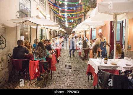 Alfama district Lisbon, people have a dinner in tipical restaurant in the street. Stock Photo