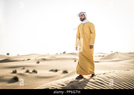 Handsome arabian man with traditional dress in the desert of Dubai ...