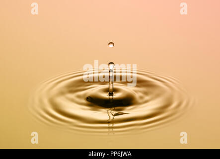 Drop falling on smooth surface of water Stock Photo