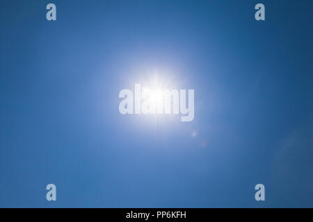 Lens flare optical effect over blue sky with sunlight Stock Photo