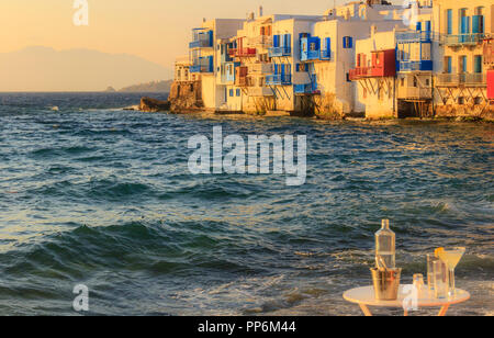 View of the famous pictorial Little Venice bay of Mykonos town in Mykonos island in Greece. Splashing waves over cocktail and table of the bars. Stock Photo